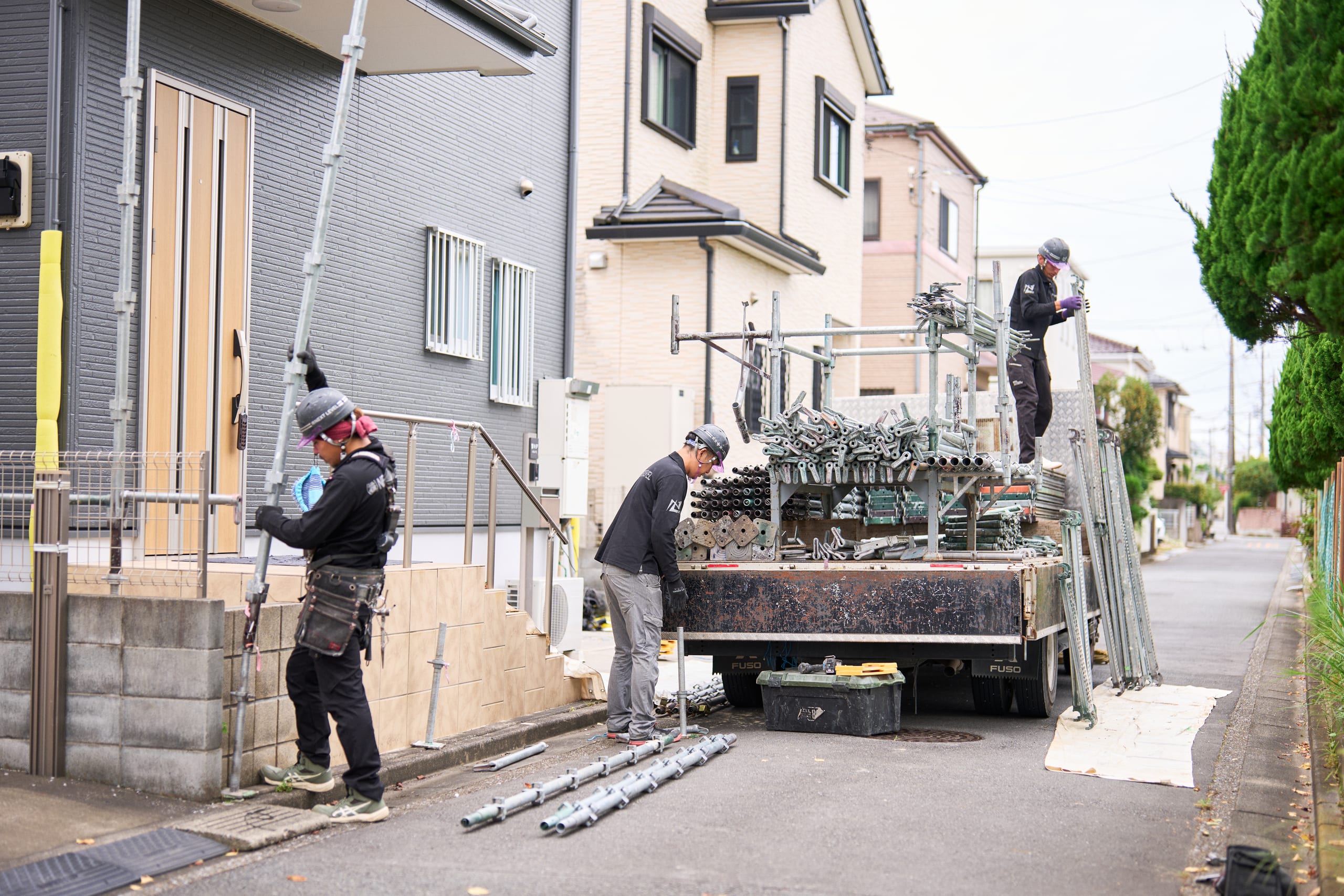 現場で連携して足場を組み立てる作業員